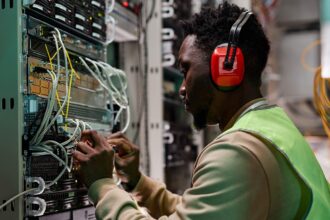 technician setting up a network in a server room wearing headphones