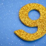 shutterstock 402603583 number nine 9 in gold sparkles over a blue background