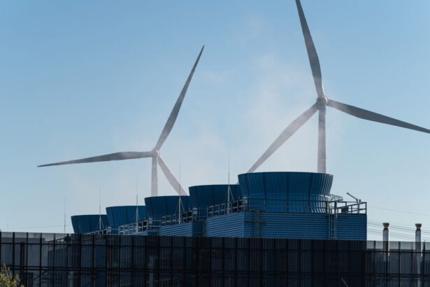 The heat vents of a data center in the foreground, with two large wind turbines visible in the background to show green renewable being used at a green data center.