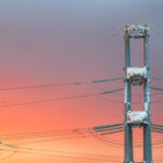 High voltage power transmission line on sunset background