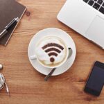 Still life of mobile devices on desk with coffee with wifi symbol