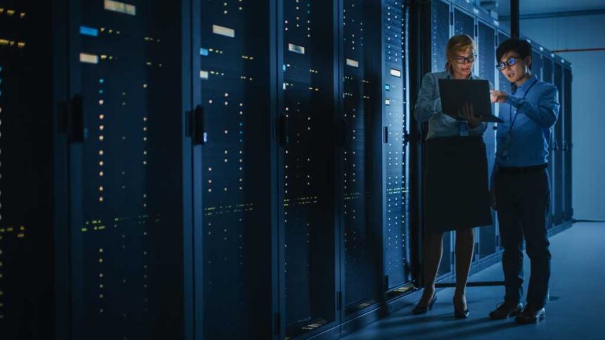 Shot of Dark Data Center With Multiple Rows of Fully Operational Server Racks. Modern Telecommunications, Cloud Computing, Artificial Intelligence, Database, Supercomputer. Pink Neon Light.