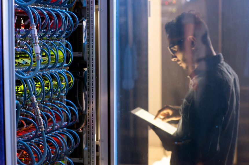 man checking a data center server on his tablet