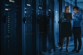 Shot of Dark Data Center With Multiple Rows of Fully Operational Server Racks. Modern Telecommunications, Cloud Computing, Artificial Intelligence, Database, Supercomputer. Pink Neon Light.