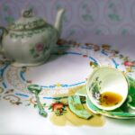 dropped  china cup of tea on a broken saucer with spilled tea on table cloth