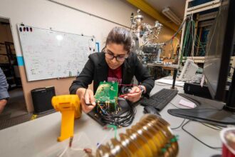 Kaushalya Jhuria in the lab testing the electronics that are part of the experimental setup used for making qubits in silicon.