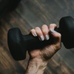 Person holding a dumbbell amid calls by IT professionals for stronger AI regulation, according to SolarWinds research.