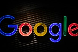 Google logo neon sign as the company announces a restructuring of its divisions and leadership to accelerate its AI initiatives.