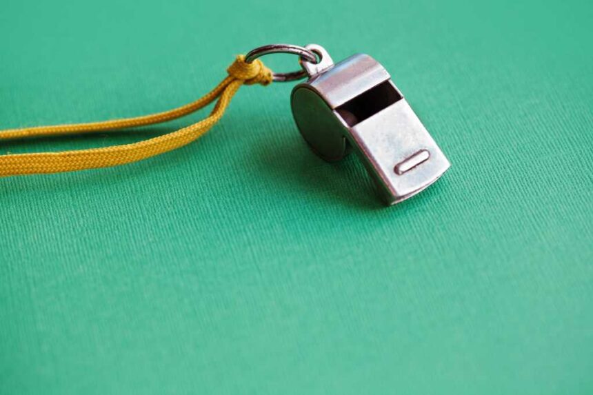 shutterstock 1193930281 silver whistle on green paper background