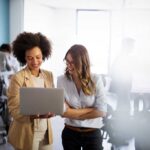 Happy multiethnic smiling business women working together in office