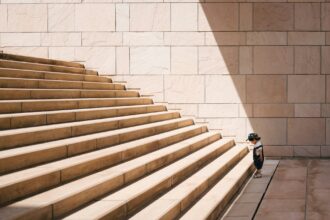 Kid facing the challenge of large stairs illustrating the diminishing returns that OpenAI is reportedly facing with the training and development of its latest AI model.