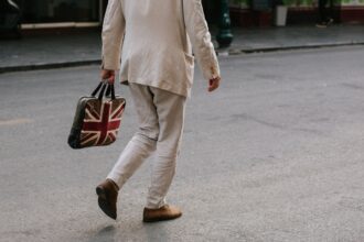 Photo of a man carrying a bag with the Union Jack flag of the UK as Prime Minister Keir Starmer unveils an AI action plan aiming to harness artificial intelligence technologies to unlock economic potential, transform public services such as the NHS, and more.