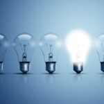 shutterstock 424982974 five light bulbs on a blue background one glowing light bulb