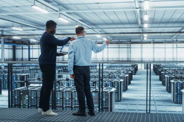 Two male colleagues in data center looking at servers