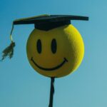 A smiley face wearing a graduation cap illustrating Carl by the Autoscience Institute, the first AI system crafting academic research papers to pass a rigorous double-blind peer-review process and raising questions about ethics including the role of artificial intelligence in academic settings.