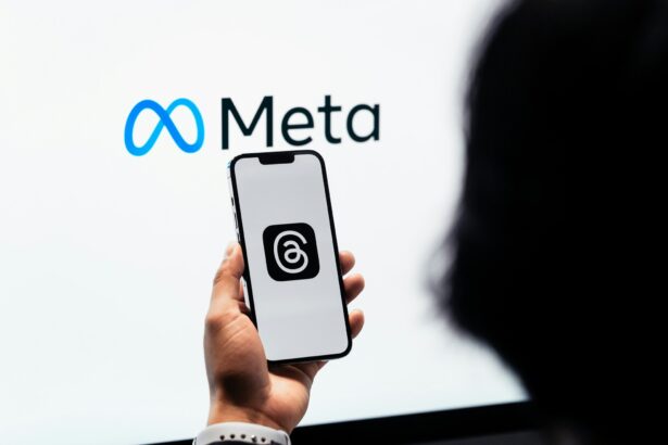 Person holding a phone displaying the Threads social media platform in front of the Meta logo as the company confirms plans to utilise content shared by its adult users in the EU (European Union) on platforms like Instagram and Facebook to train its AI models.