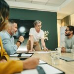 Mature businesswoman leading a discussion with her team in a boardroom. Group of creative businesspeople sharing ideas during a meeting in a modern workplace.