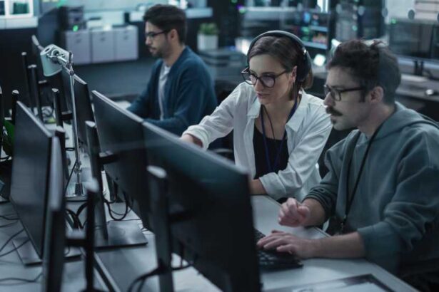 Young Team of Specialists Working on Desktop Computers and Having a Conversation at a Workplace. Female and Male Software Developers Discussing a Solution for Their Artificial Intelligence Project