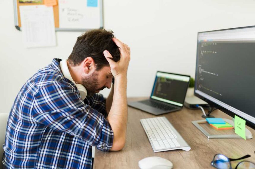Stressed upset programmer having problems developing new software and looking worried because of the coding of an app