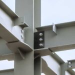 Steel joints. Mounting bolted connection of steel beams before welding. Metal construction covered protective gray primer. Close-up.