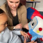 Mya, age 3, and her mum, Vicky, playing with the AI toy, Gabbo, during an observation at the University of Cambridge’s Faculty of Education.