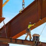 Rusty steel girder and two meter web installed on a bridge abutment and scaffolding as part of a new freeway interchange. Building construction infrastructure project.